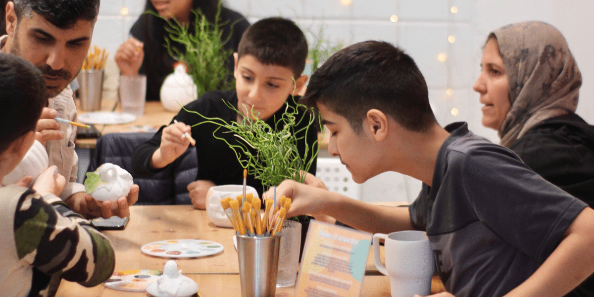 refugee families enjoy a pottery painting session