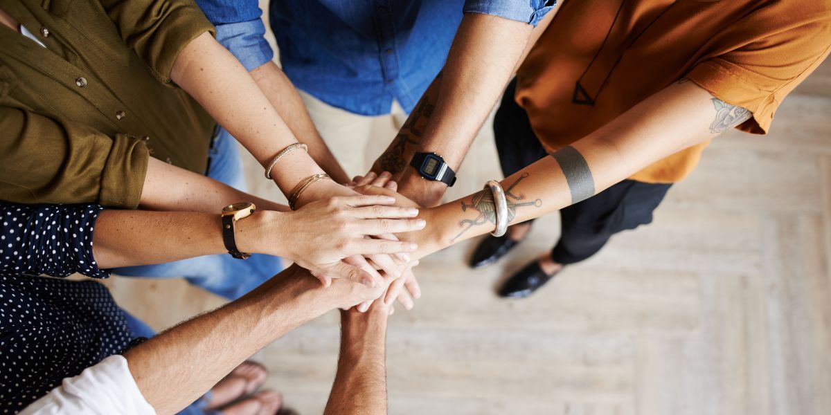 birds eye view of four sets of hands connecting